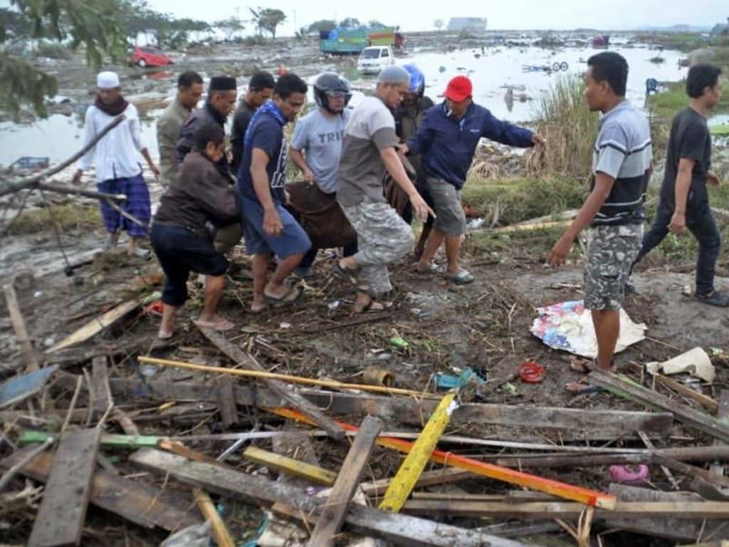 Helfer bergen in Palu ein Tsunami-Opfer. Foto: AP