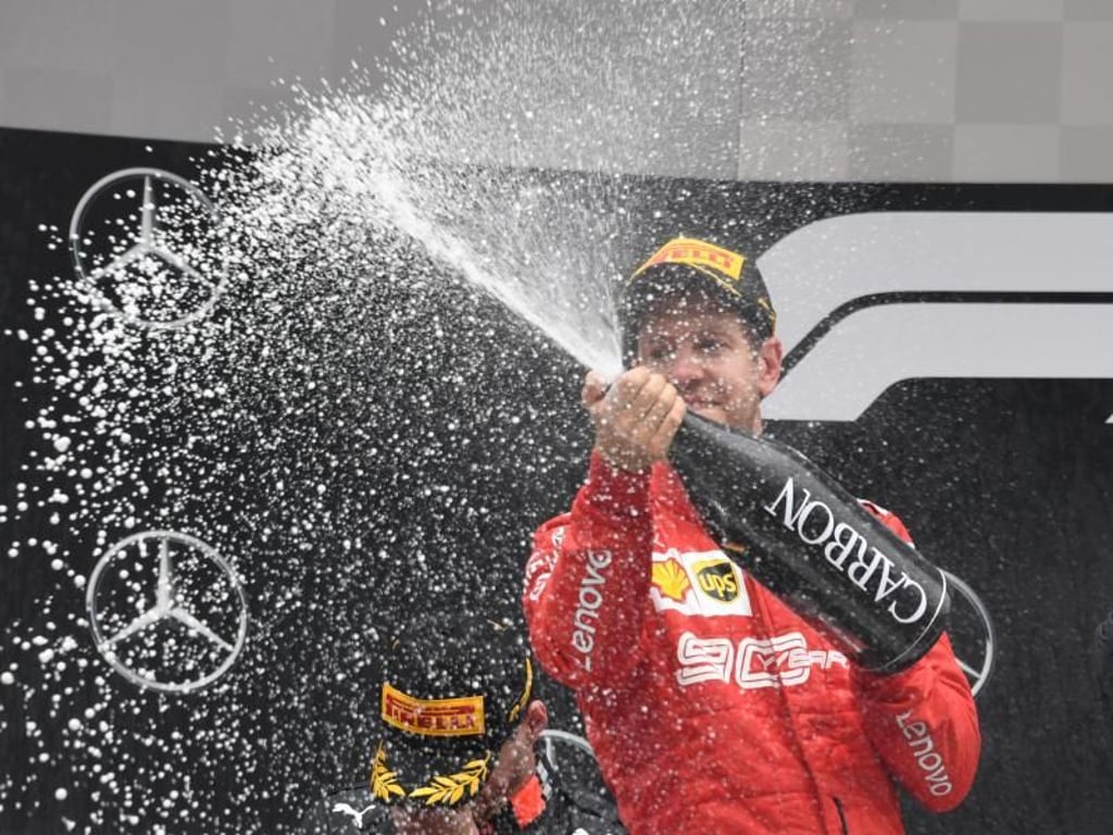 Nach der furiosen Aufholjagd spritzt der sichtlich zufriedene Ferrari-Pilot Champagner in die Menge. Foto: Uli Deck