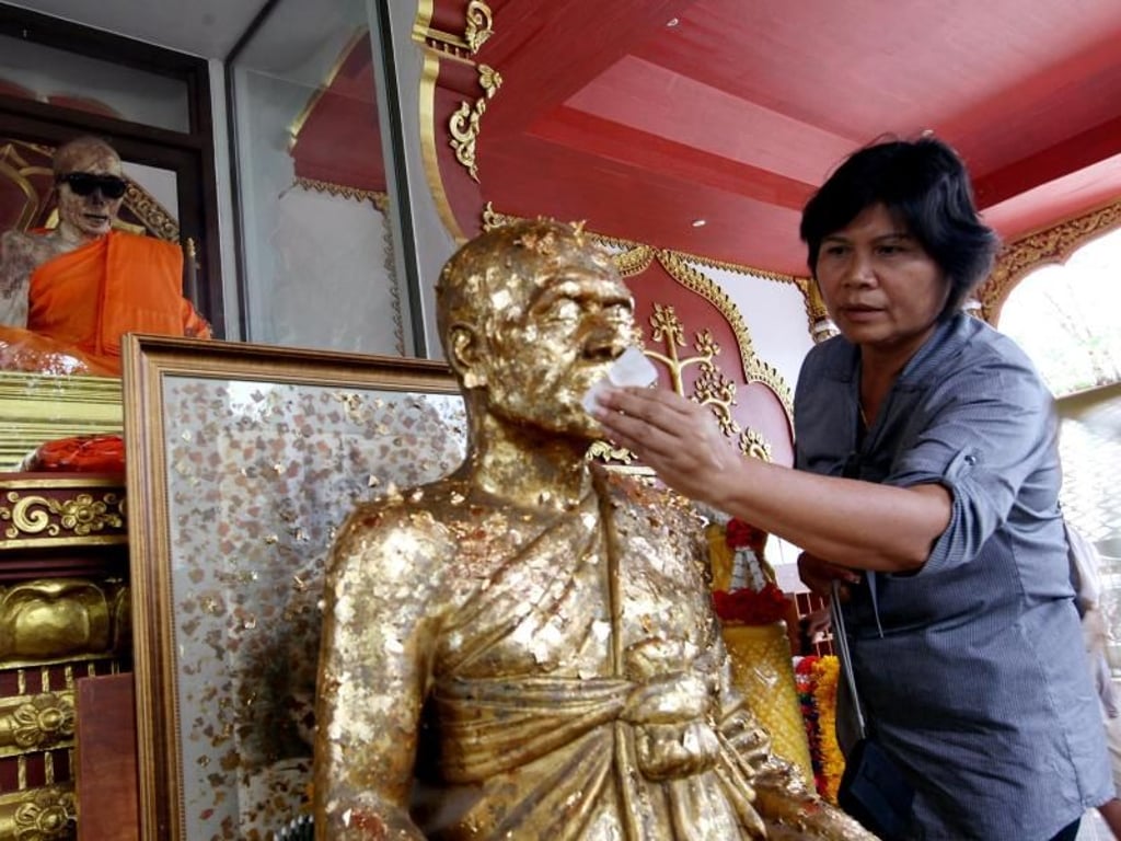 Tradition auf Koh Samui: Die Figur eines buddhistischen Mönchs wird mit Blattgold belegt. Foto: Rungroj Yongrit/Archiv