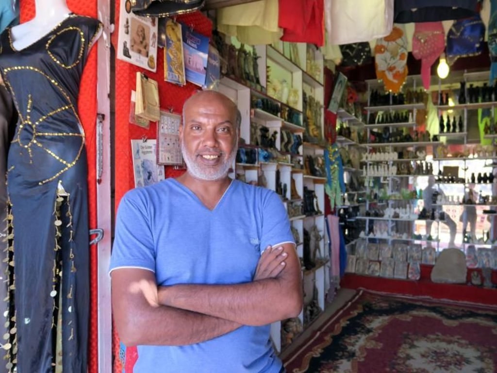 Hany Sayed Ahmed ist Händler in der Basarstraße vor dem Tempel von Edfu. Sein Geschäft leidet unter der Touristenflaute. Foto: Simone A. Mayer/dpa-tmn