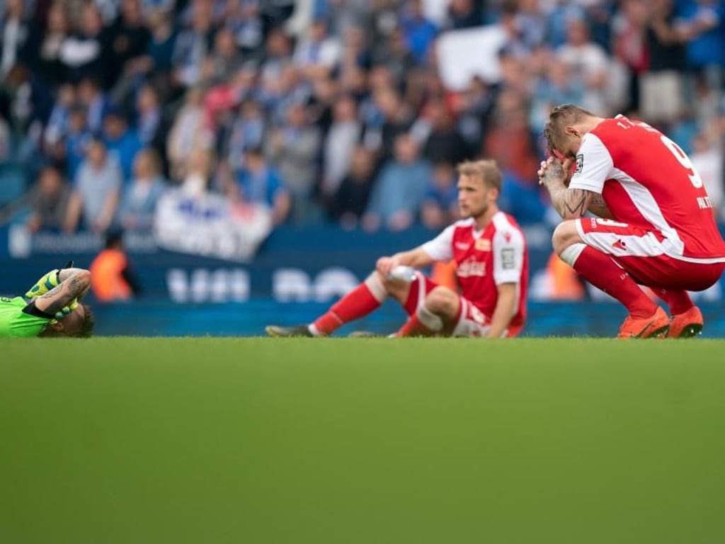 Die Union-Spieler sitzen nach dem Schlusspfiff enttäuscht auf dem Rasen. Foto: Bernd Thissen
