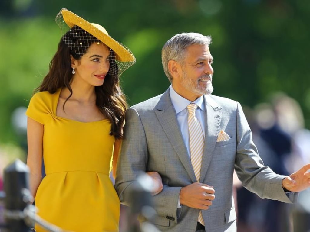 Auch George und Amal Clooney, die ein strahlend gelbes Kleid von Stella McCartney trägt, waren eingeladen. Meghan und Amal sollen gut miteinander befreundet sein. Foto: Gareth Fuller/PA Wire