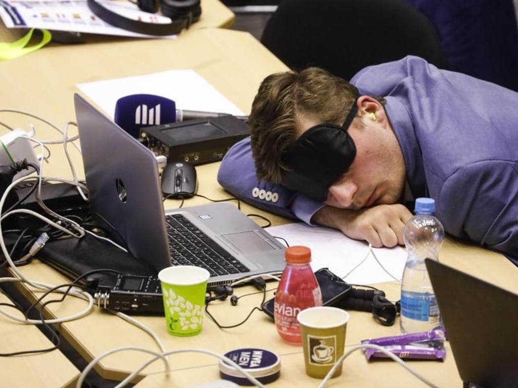 Ein Journalist ruht sich während des nächtlichen Verhandlungsmarathons der EU-Staats- und Regierungschefs im Pressezentrum aus. Foto: Thierry Roge/BELGA