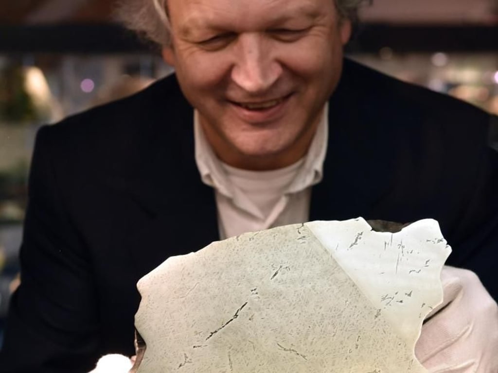 Peter Masberg, Leiter des Mineralogischen Museums der Universität Marburg, betrachtet den Meteoriten von Treysa/Rommershausen. Foto: Uwe Zucchi