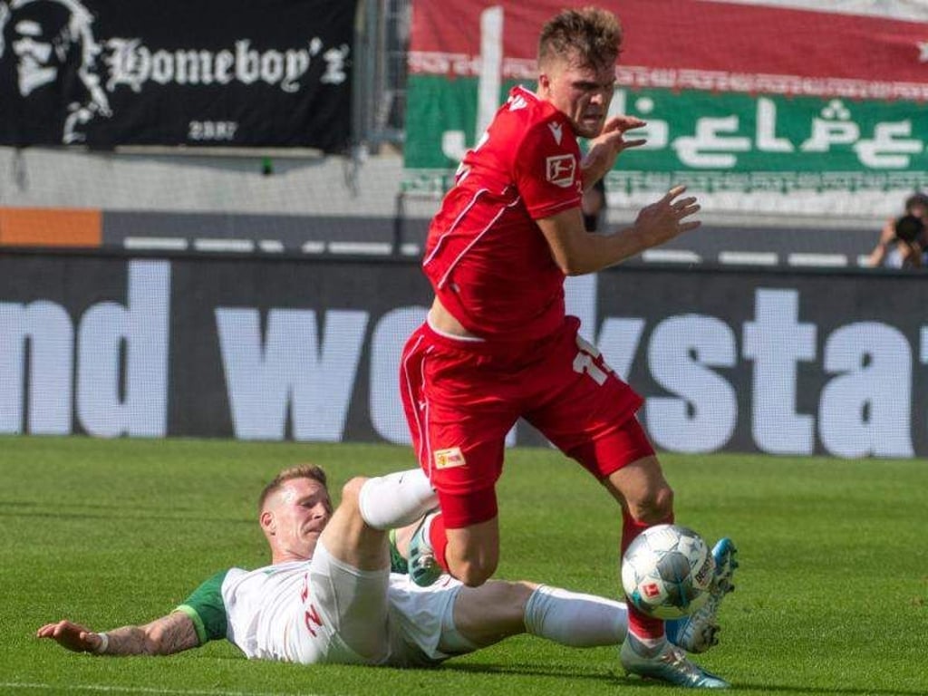 Augsburgs Andre Hahn (l) stoppt Berlins Marius Bülter mit unfairen Mitteln. Foto: Stefan Puchner