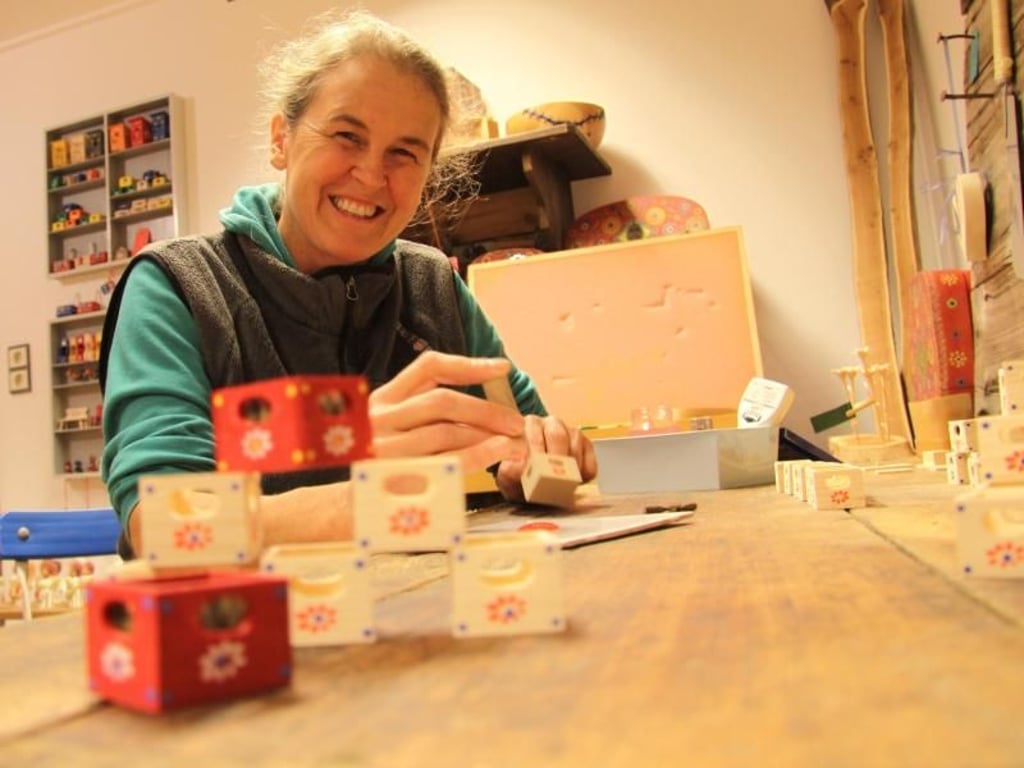 Die Holzkünstlerin Barbara Moderegger interpretiert traditionelles Spielzeug modern - und fertigt zum Beispiel Miniatur-Bierkisten an. Foto: Larissa Loges