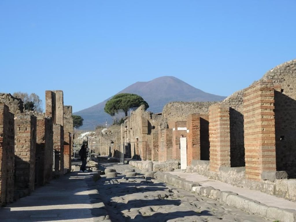 Eine Straße im Archäologischen Park Pompeji mit Blick auf den Vesuv. Foto: Lena Klimkeit