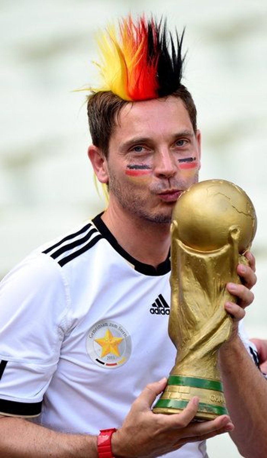 epa04271290 Supporter of Germany cheers prior to the FIFA World Cup 2014 group G preliminary round match between Germany and Ghana at the Estadio Castelao in Fortaleza, Brazil, 21 June 2014. (RESTRICTIONS APPLY: Editorial Use Only, not used in association with any commercial entity - Images must not be used in any form of alert service or push service of any kind including via mobile alert services, downloads to mobile devices or MMS messaging - Images must appear as still images and must not emulate match action video footage - No alteration is made to, and no text or image is superimposed over, any published image which: (a) intentionally obscures or removes a sponsor identification image; or (b) adds or overlays the commercial identification of any third party which is not officially associated with the FIFA World Cup) EPA/GEORGI LICOVSKI EDITORIAL USE ONLY +++(c) dpa - Bildfunk+++