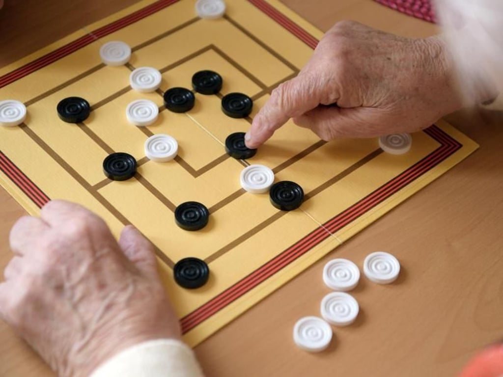 Die Bewohner der betreuten Senioren-WG in Weimar (Thüringen) spielen auch mal zusammen Mühle. Foto: Candy Welz
