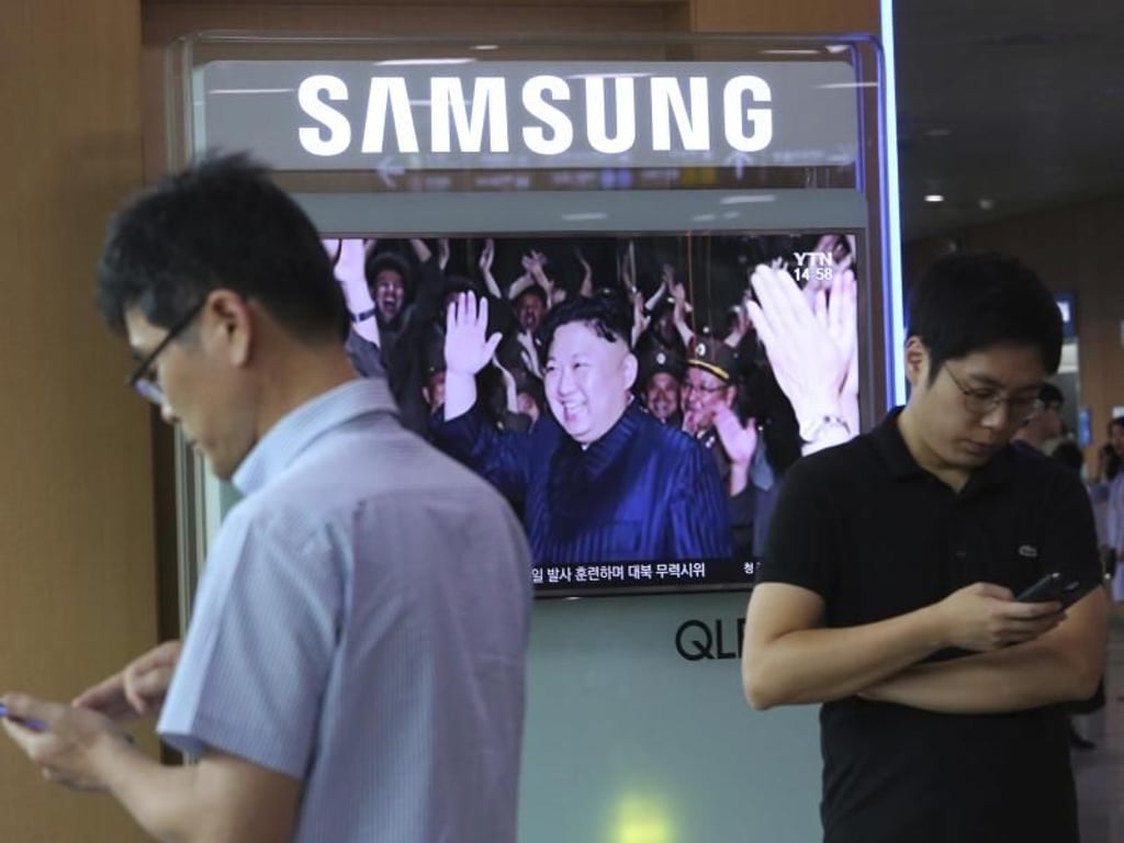 Gelassenheit in Seoul: Während ein Fernsehsender über einen nordkoreanischen Raketentest berichtet, studieren Pasanten in aller Ruhe ihre Smartphones. Foto: Ahn Young-Joon