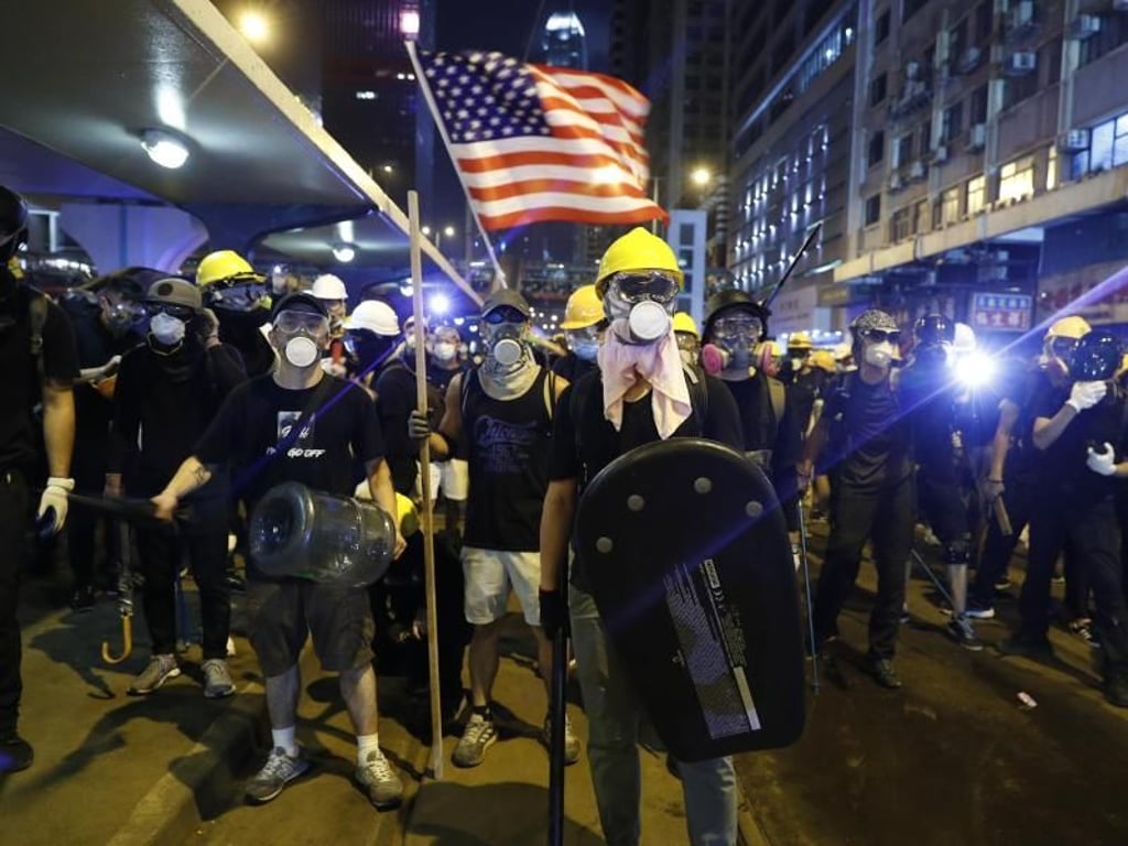 Demonstranten schwenken eine US-Flagge und bereiten sich auf die Konfrontation mit der Polizei vor. Foto: Vincent Yu/AP