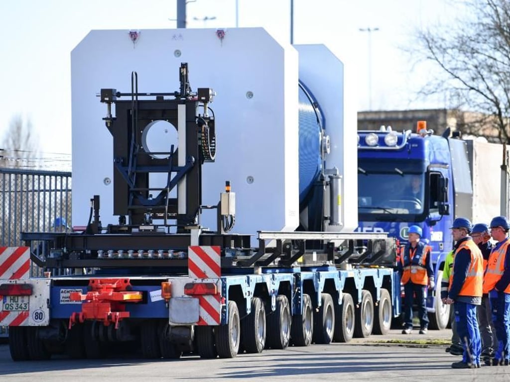 Ein Castor-Behälter wird vor dem AKW Obrigheim mit Hilfe eines Lastwagens auf ein Schiff geschoben. Wo der Atommüll einmal lagern wird, ist weiterhin offen. Foto: Uwe Anspach