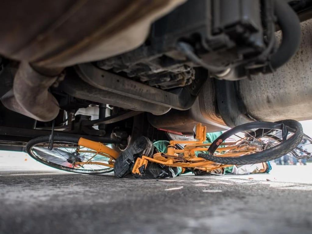 Hier kam kein Mensch zu Schaden: Ein Dummy und sein Fahrrad liegen nach einem Crash-Test unter einem Lastwagen. Foto: Guido Kirchner