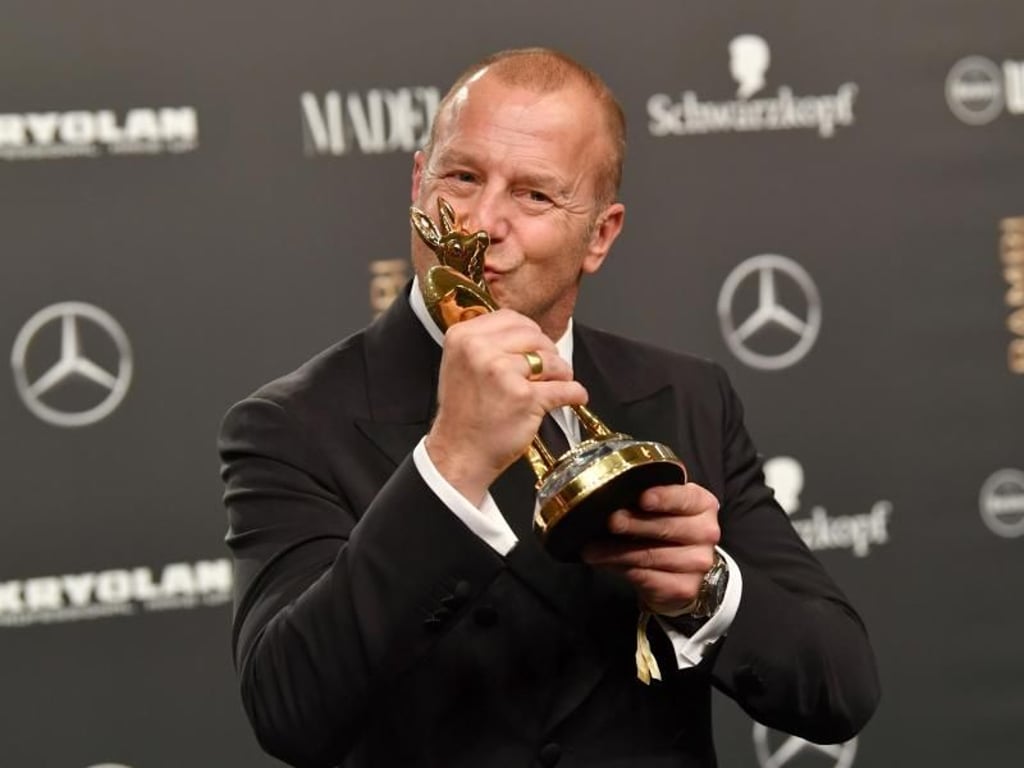 Küsschen fürs Reh: Heino Ferch, «Schauspieler National», mit seinem Bambi. Foto: Jens Kalaene
