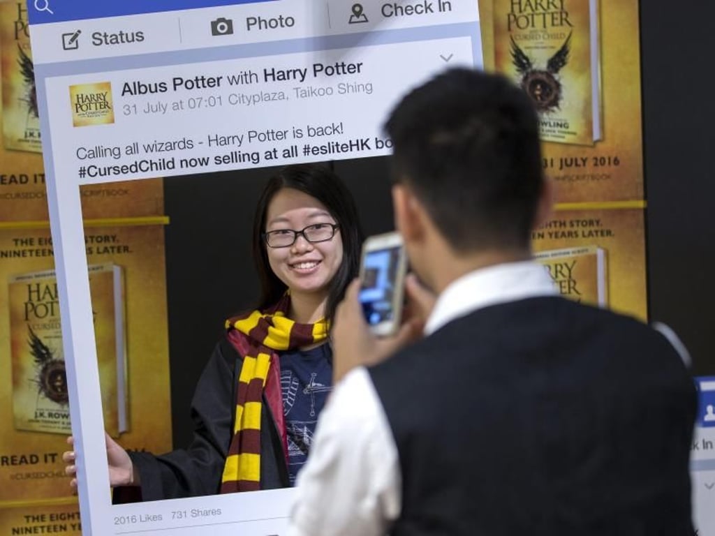 Ein Harry Potter-Fan posiert in Hong Kong für ein Foto mit dem neu erschienenen Buch «Harry Potter and the Cursed Child». Foto: Jerome Favre