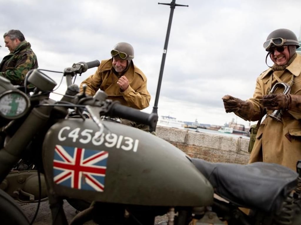 Drei Briten stehen in historischen Uniformen mit historischen Motorrädern in der Altstadt von Portsmouth. Foto: Kay Nietfeld
