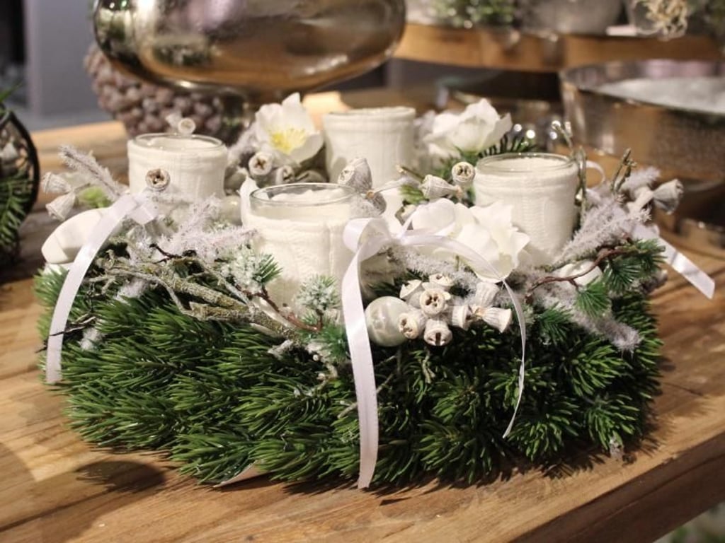 Zweige, Schleife, ein paar Blüten: In Weiß sieht der Adventskranz edel aus. Foto: Fachverband Deutscher Floristen/Oliver Ferchland