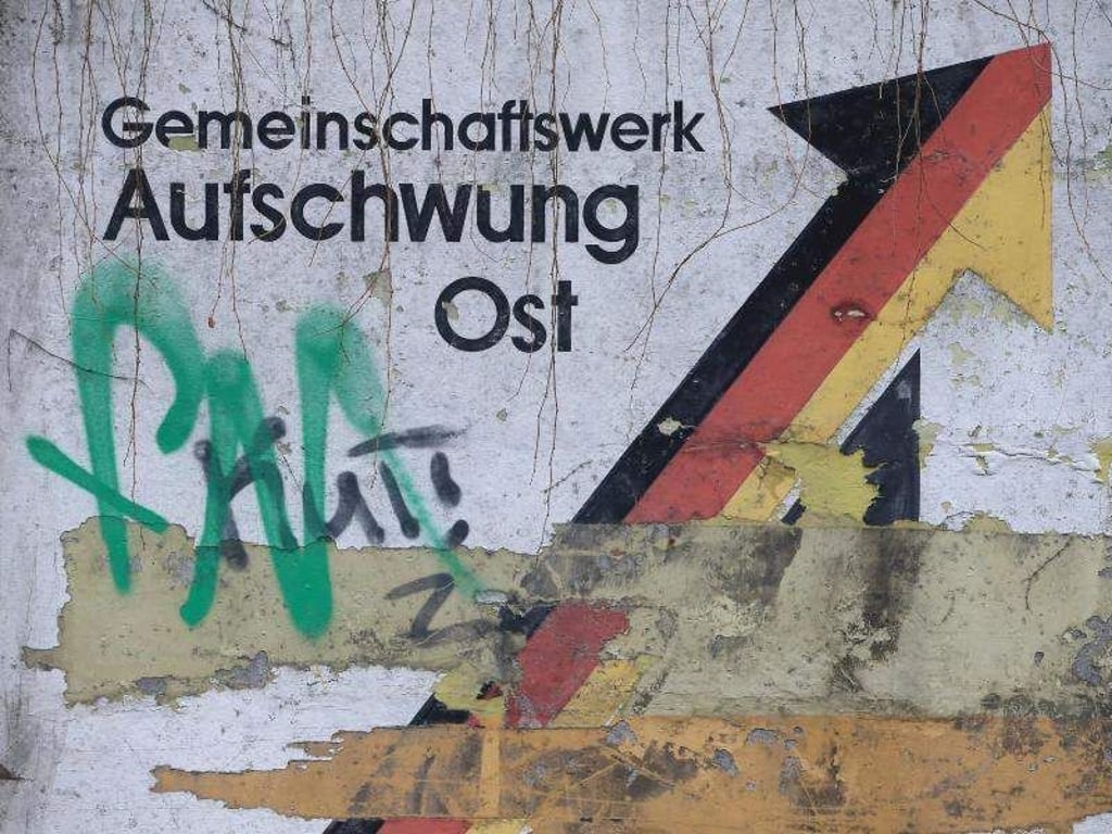 Der verwitterte Schriftzug «Gemeinschaftswerk Aufschwung Ost» in Magdeburg. Fot: Jens Wolf/Archivbild Foto: Jens Wolf