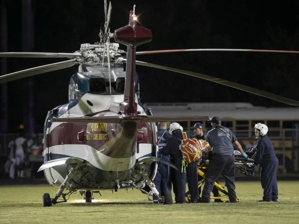 Nachdem bei einem Footballspiel in Florida Schüsse gefallen sind, transportieren Sanitäter eine verletzte Person zu einem Hubschrauber. Foto: Allen Eyestone/Palm Beach Post via ZUMA Wire