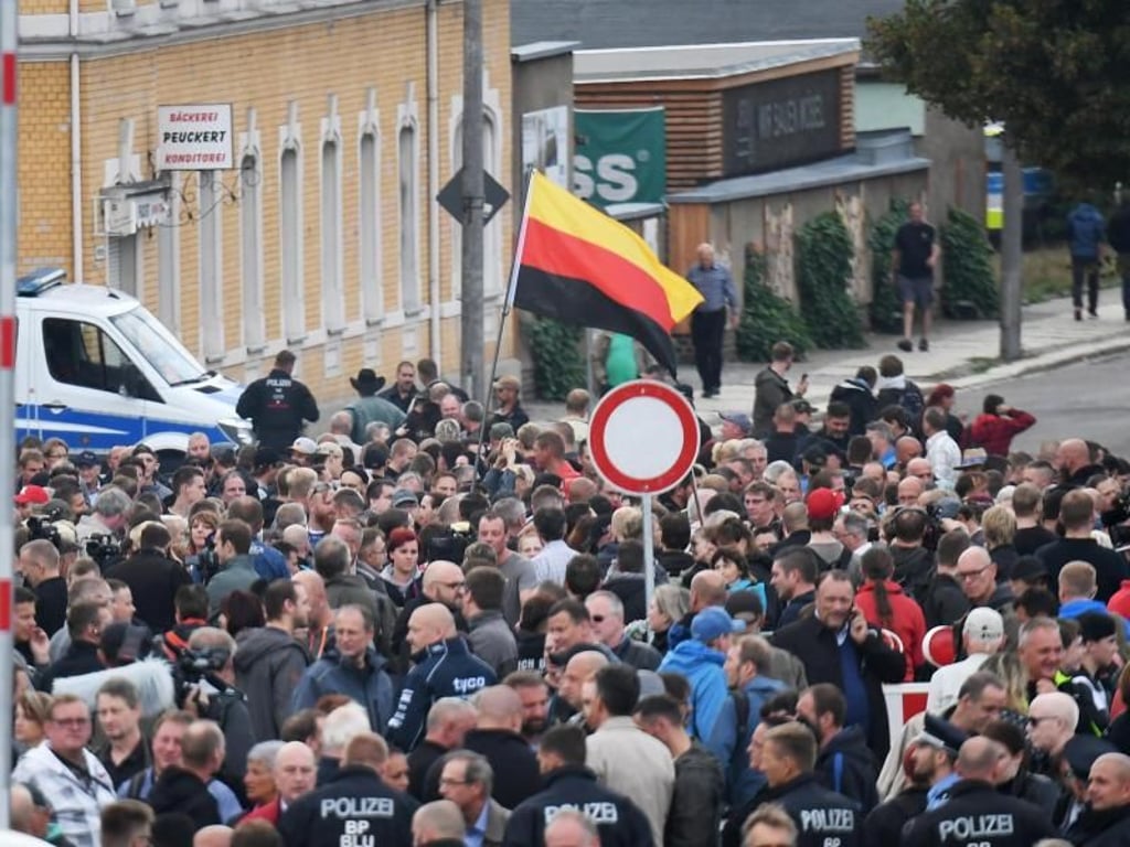 Demonstranten mit einer umgedrehten Deutschlandfahne versammeln sich vor dem Stadion vom Chemnitzer FC. Foto: Ralf Hirschberger