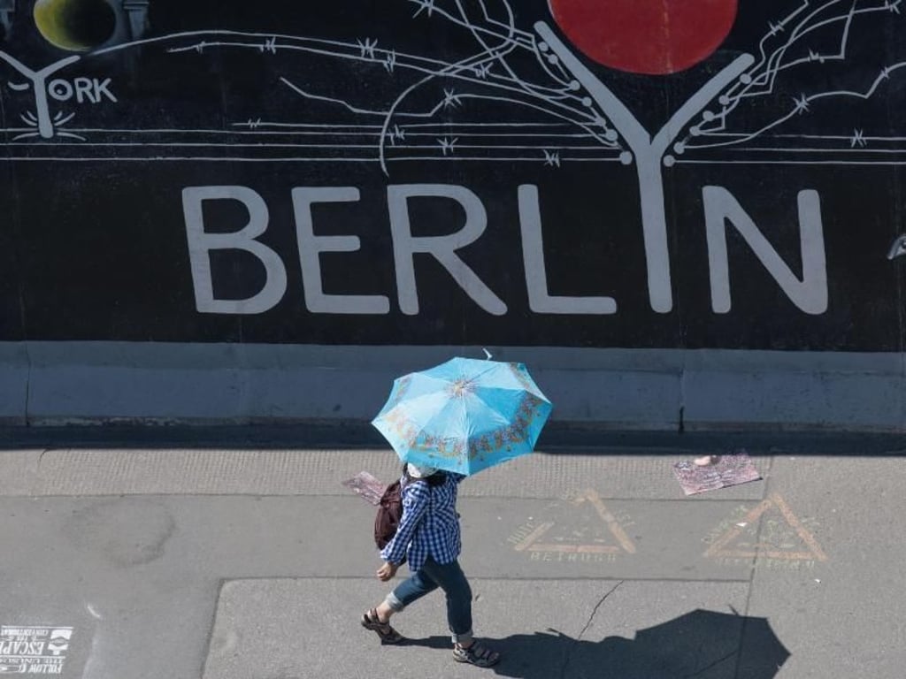 Nicht nur bei Nieselwetter hilfreich: Eine Touristin nutzt einen Regenschirm als Schutz gegen die Sonne. Foto: Jörg Carstensen