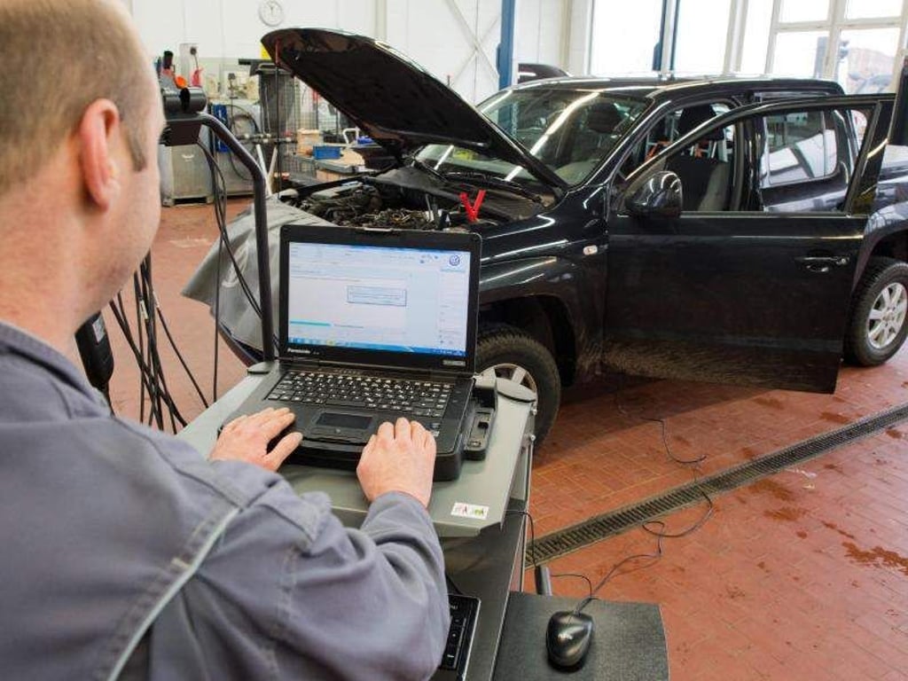Ein Kfz-Meister lädt ein Software-Update für das Steuergerät der Motorelektronik auf einen Volkswagen Amarok mit Dieselmotor. Foto: Julian Stratenschulte