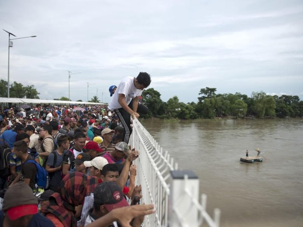Migrantenauf dem Weg von Guatemala nach Mexiko springen von einer Grenzbrücke in den Fluss Suchiate. Foto: Oliver De Ros/AP
