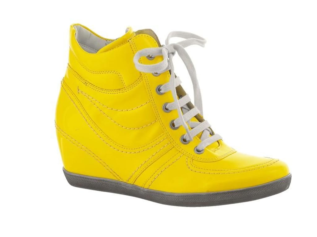 Der Turnschuh trägt in dieser Saison laute Farben: Ein knalliges Gelb ziert diesen Sneaker mit Keilabsatz von Wenz (ca. 120 Euro). Foto: Wenz/dpa-tmn