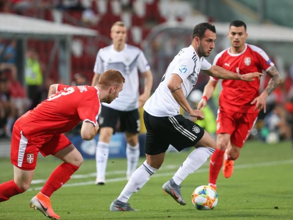 Levin Öztunali (M) aus Deutschland spielt den Ball an Miroslav Bogosavac (l) aus Serbien vorbei. Foto: Cezaro De Luca