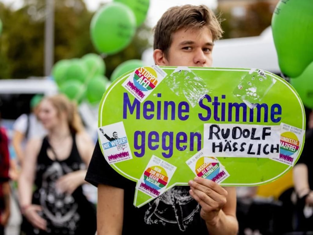 "Meine Stimme gegen Rudolf Hässlich" steht bei einer der Gegendemonstration auf einem Schild. Foto: dpa