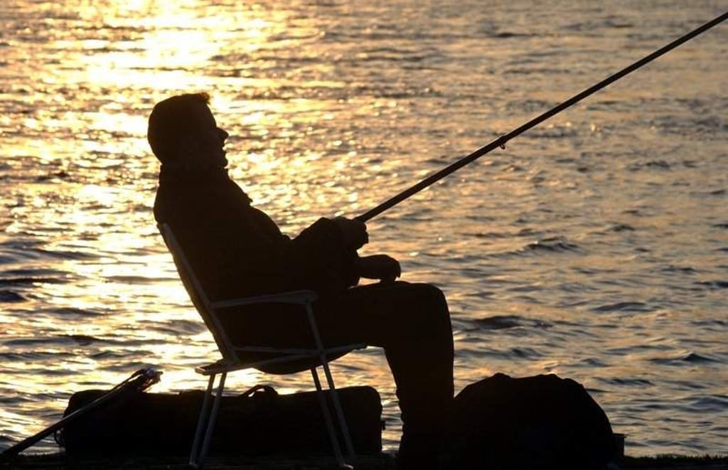 Ein Angler sitzt im Licht der untergehenden Sonne. Der Angelsport hat auch in Sachsen-Anhalt viele Freunde. Foto: dpa