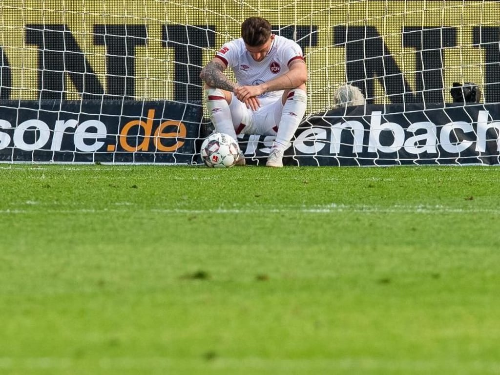 Der Nürnberger Tim Leibold sitzt frustriert nach dem 0:2 in Leverkusen im Tor. Foto: Guido Kirchner