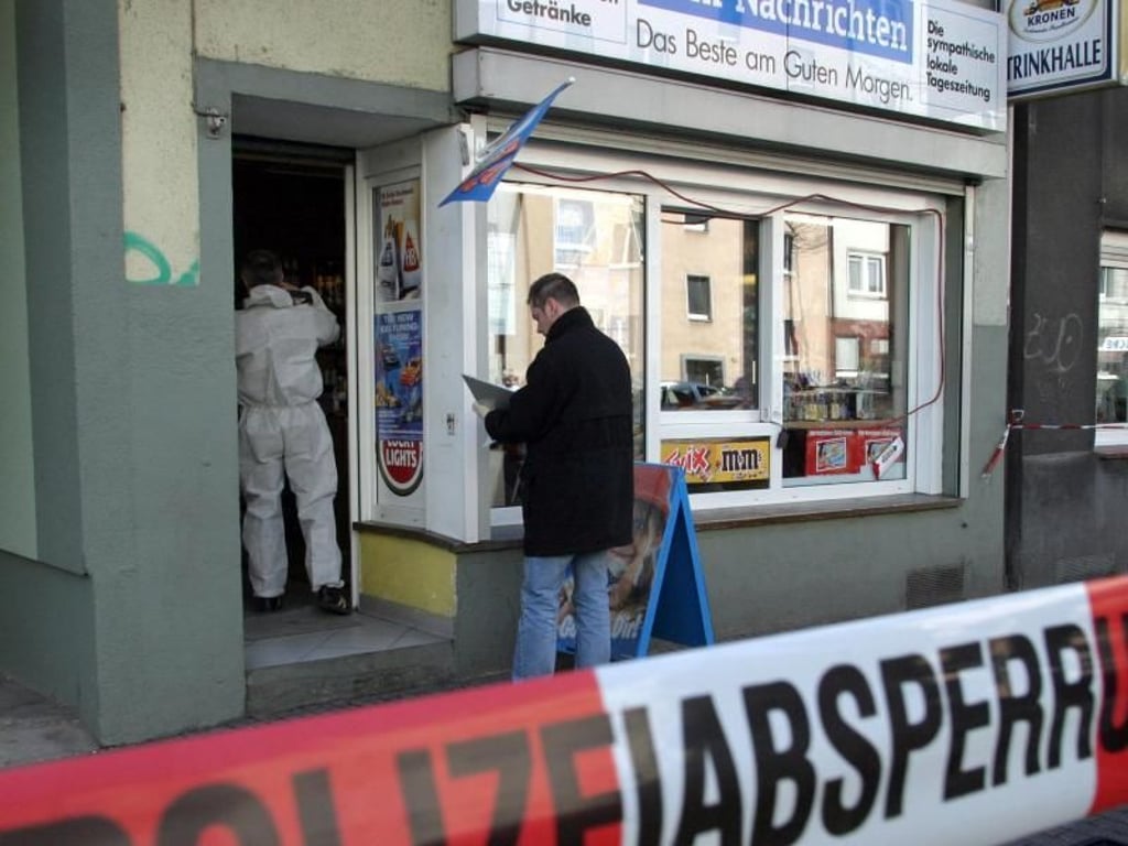 Polizeibeamte untersuchen nach einem mutmaßlichen NSU-Mord in Dortmund einen Kiosk auf Spuren. Foto: Nils Foltynowicz/Archiv