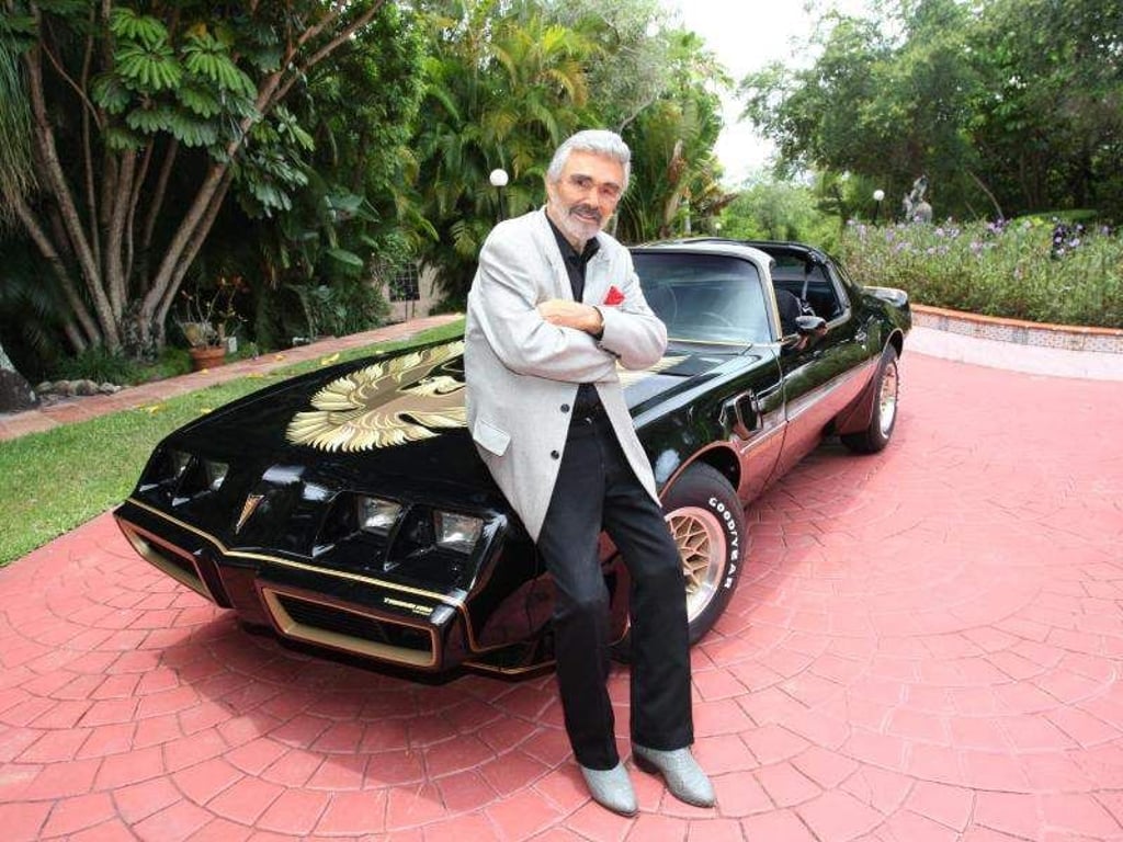 Schauspielers Burt Reynolds steht an seinem schwarz-goldenen Sportwagen der Marke Pontiac Trans Am (1979). Das Auto gehört zu Filmmemorabilien, Kleidungsstücken und Möbeln aus dem Privatbesitz des Schauspielers, die am 15. und 16. Juni in Beverly Hills versteigert werden. Foto: Juliens Auctions