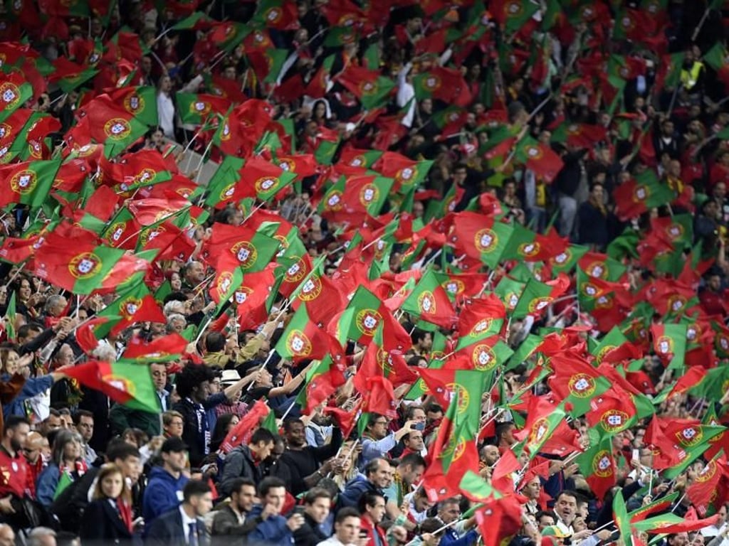 Die portugiesischen Fans schwenken auf der Tribüne ihre Nationalfahnen. Foto: Martin Meissner/AP
