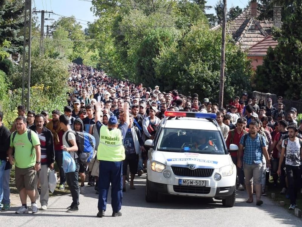 Ungarische Polizisten begleiten am 19.9.2015 einen Flüchtlingszug durch Hegyeshalom (Ungarn) zur Grenze nach Österreich. Foto: Herbert P. Oczeret/APA
