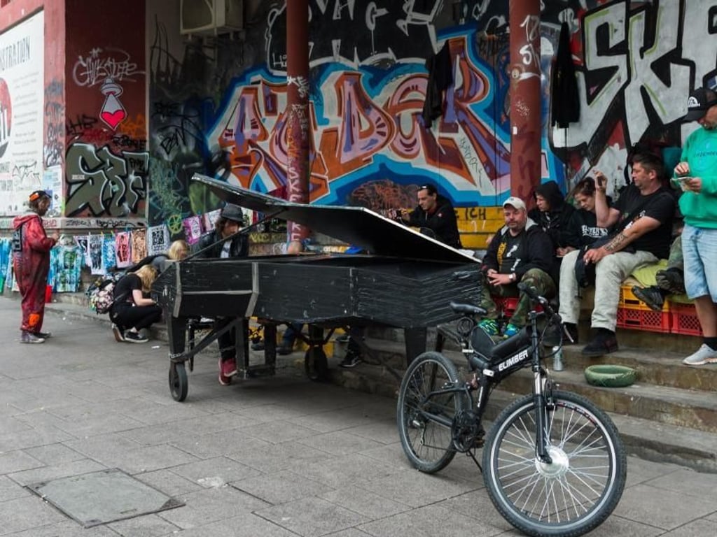 Davide Martello spielt in Hamburg vor der Roten Flora Klavier. Der Pianist spielte bereits bei den Protesten in der Türkei, der Ukraine und nach dem Anschlag in Paris. Foto: Christophe Gateau