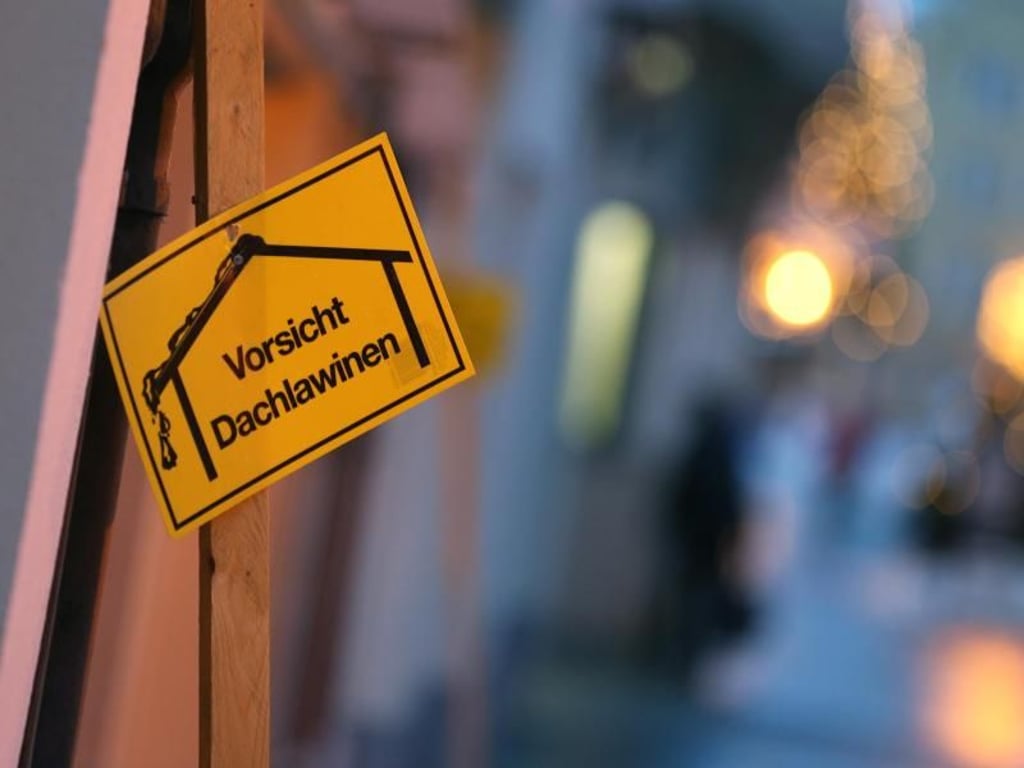 Ein Schild warnt in der Fußgängerzone von Füssen vor Dachlawinen. Foto: Karl-Josef Hildenbrand