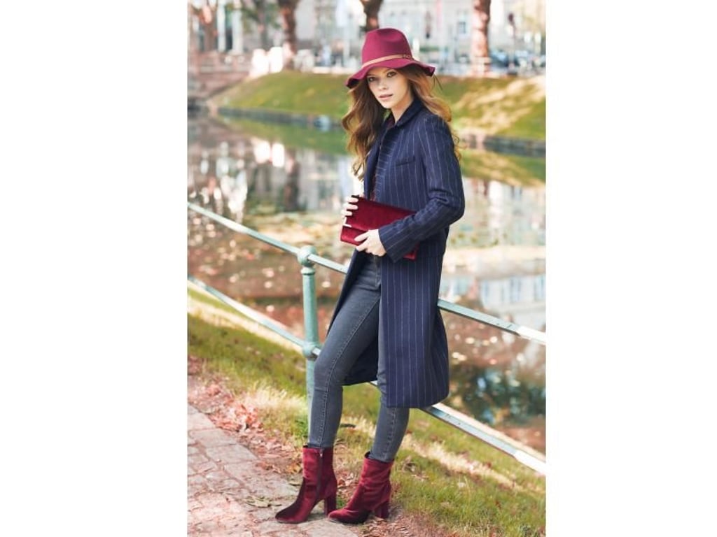 Auch Accessoires gibt es in dieser Saison im Trendstoff Samt - wie hier bei Deichmann an Schuhen oder Tasche zu sehen. In Kombination mit Jeans wirkt der Look lässig (Samtstiefelette ca. 35 Euro). Foto: Deichmann/dpa-tmn