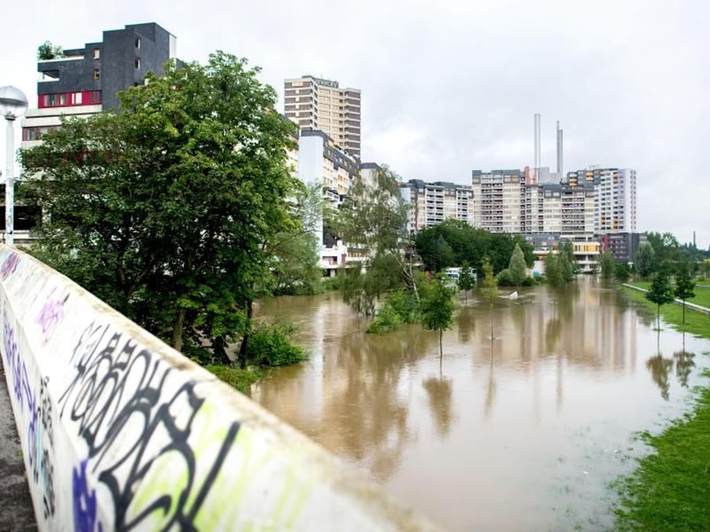 In Hannover ist die Ihme über die Ufer getreten. Im Hintergrund das Ihme-Zentrum. Foto: Hauke-Christian Dittrich