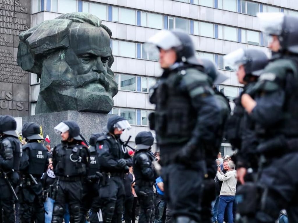 Polizisten haben sich vor dem Karl-Marx-Denkmal postiert. Foto: Jan Woitas
