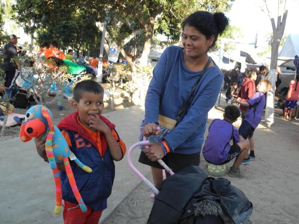 Sie will über die Grenze und lässt sich nicht entmutigen: Karen Aguilera aus Honduras steht mit ihrem Sohn Justin am Rand eines kleinen Spielplatzes in Tijuana. Foto: Amelie Richter