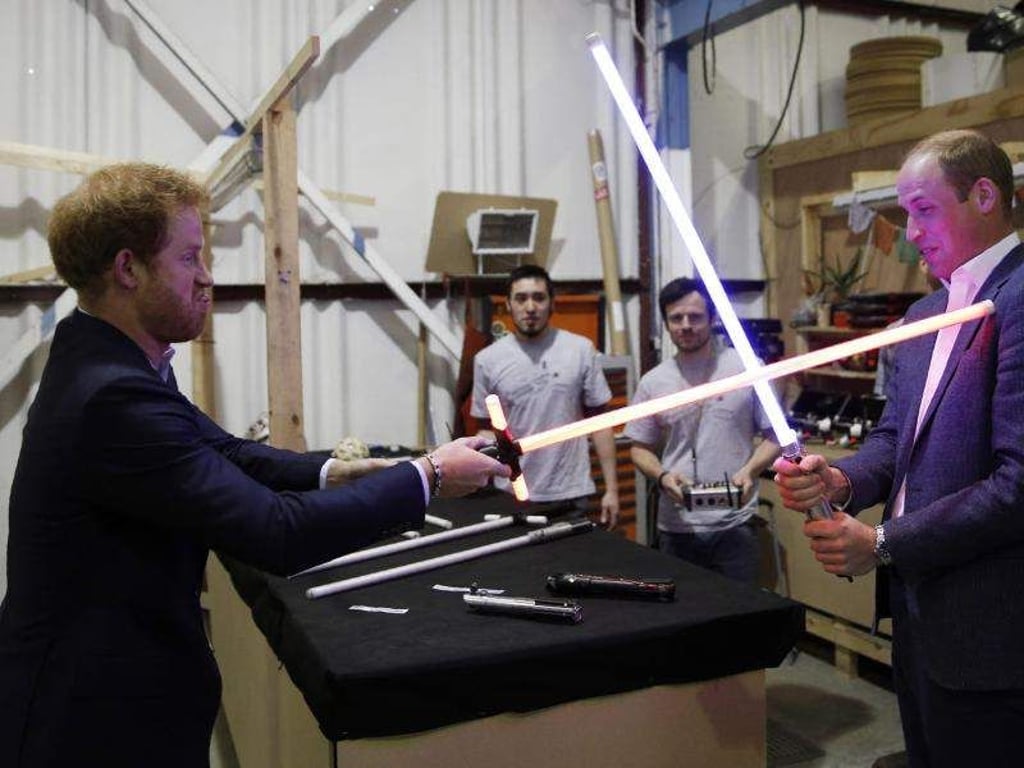 Prinz Harry schwingt ein Lichtschwert, sein Bruder William hält dagegen. Foto: Str