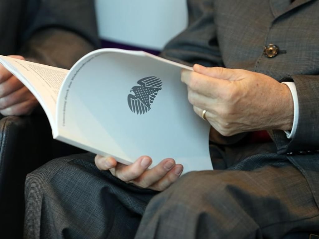 Bundestagspräsident Wolfgang Schäuble blättert im Jahresbericht 2017 des Wehrbeauftragten. Foto: Wolfgang Kumm
