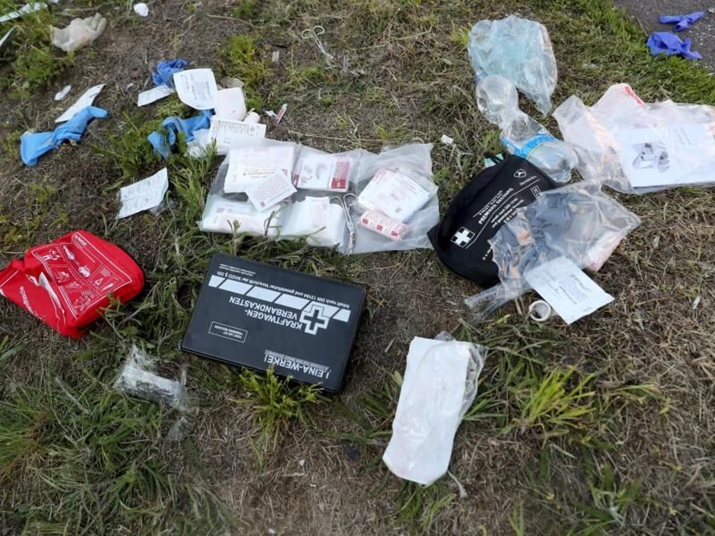 Verbandsmaterial und ein Verbandskasten an der Unfallstelle neben einem verunglückten Bus. Foto: Jan Woita