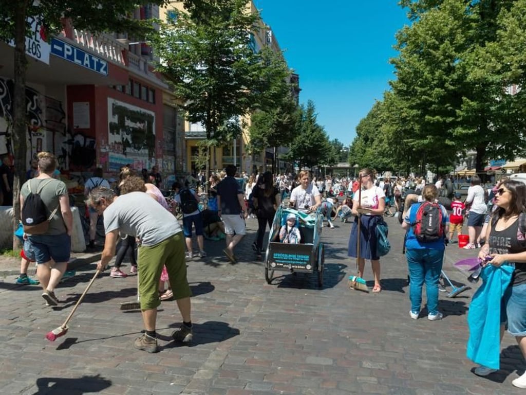 Bürgerhilfe: Einwohner räumen in Hamburg vor der Roten Flora die Straße auf. Eine Hamburgerin mobilisierte auf Facebook mehrere tausend Menschen für Aufräumarbeiten im Schanzenviertel. Foto: Christophe Gateau
