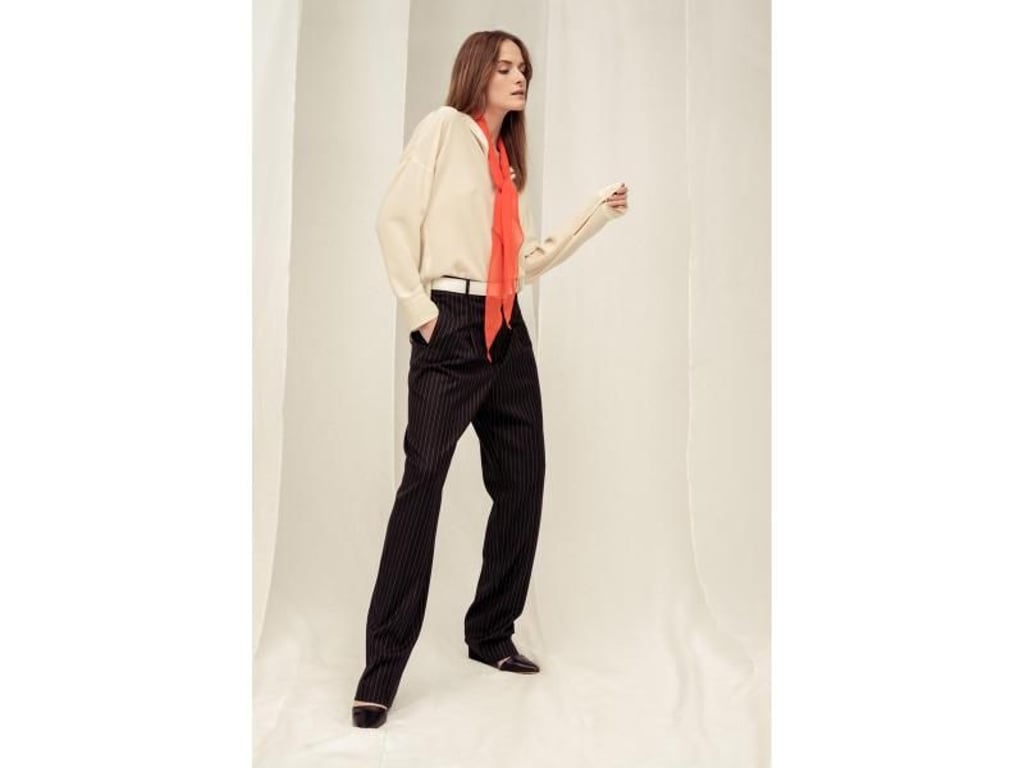 Ein Accessoire in Koralle kann ein schlichtes Outfit aufwerten. Strenesse zum Beispiel setzt auf ein Tuch (Bluse und Hose je ca. 112 Euro). Foto: Strenesse