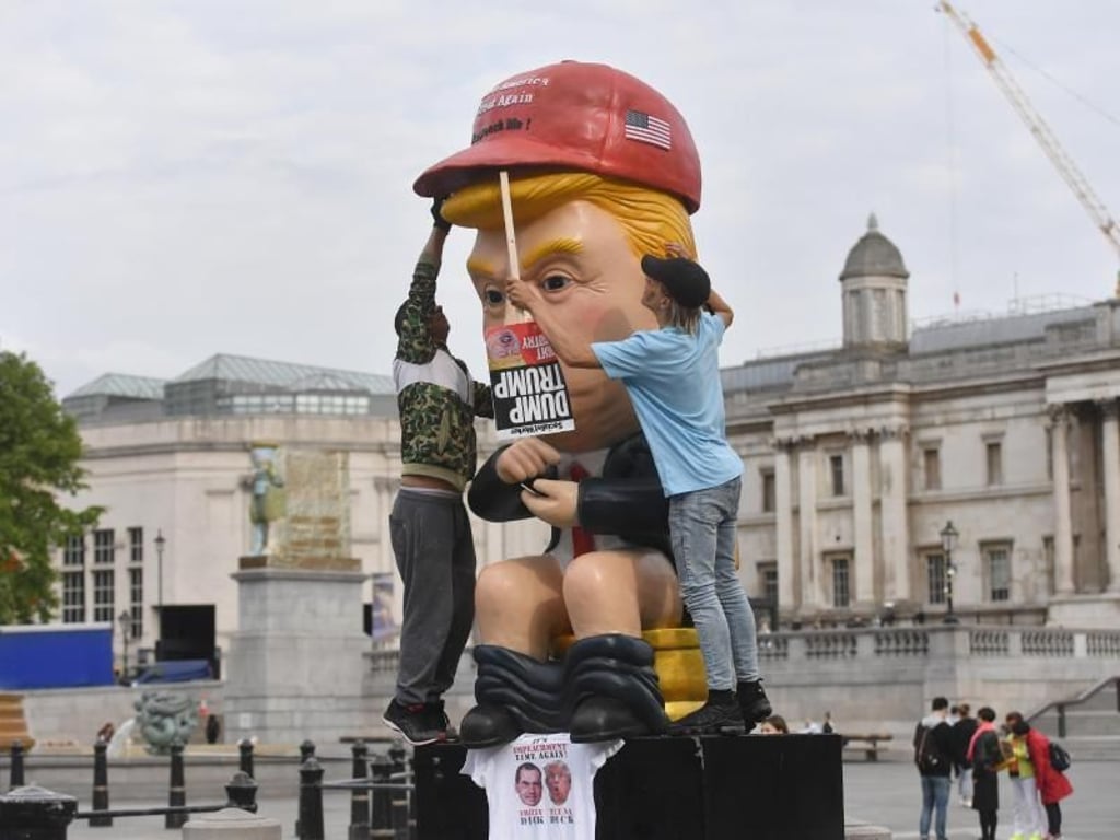 So sehen ihn manche Briten: Ein knapp 5 Meter großer sprechender Roboter, in der Anmutung von US-Präsident Trump sitzt am Trafalgar Square auf einer Goldtoilette. Foto: Jacob King/PA Wire