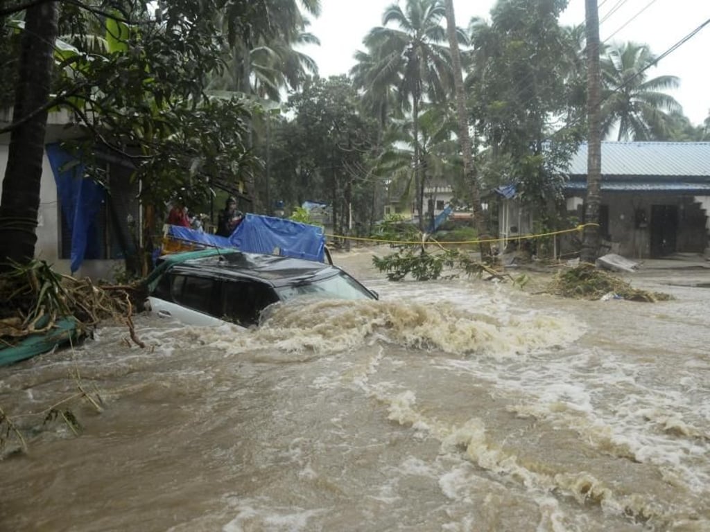 Nur noch das Dach eines Autos ragt auf einer überschwemmten Straße im Bundesstaat Kerala aus den Wassermassen. Foto: AP