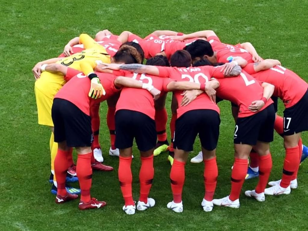 Die Mannschaft aus Südkorea schwört sich vor dem Spiel auf dem Rasen ein. Foto: Ina Fassbender